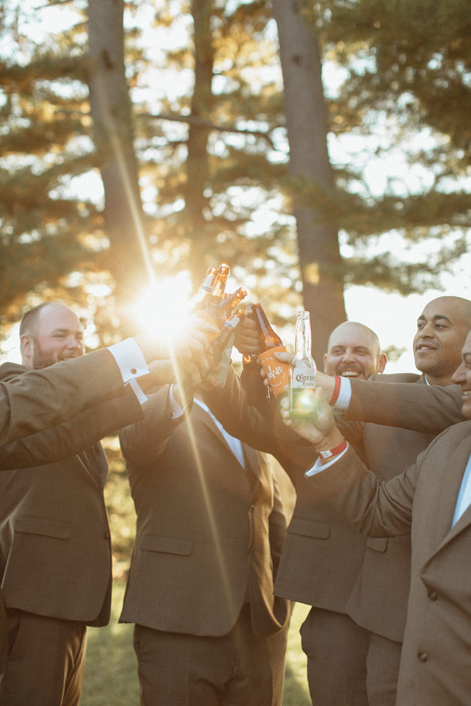 groom and groomsmen toasting their beers together captured by Charlottesville wedding photographer