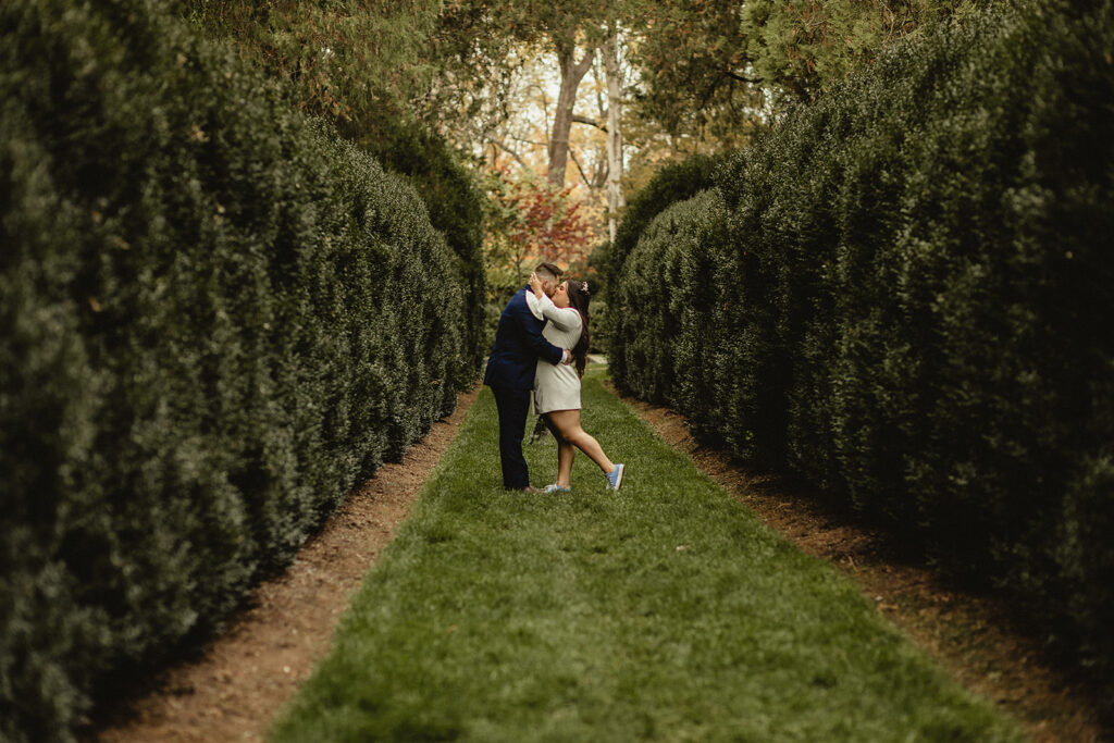 Couple standing in a garden kissing