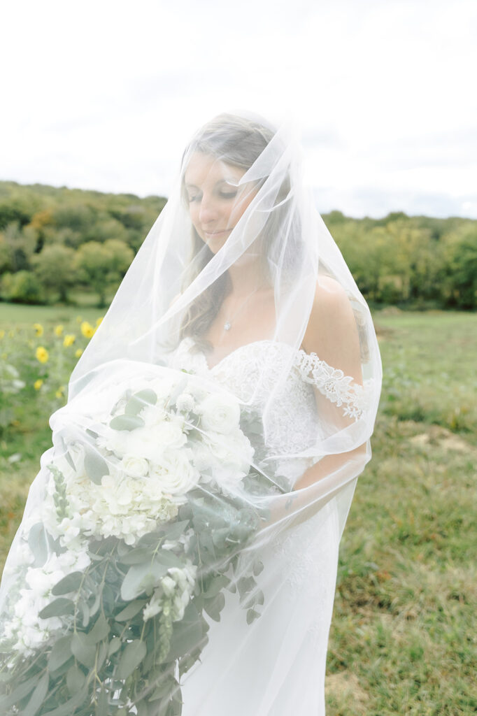 Stone ridge hollow wedding venue, bride standing with veil over her face holding her flowers
