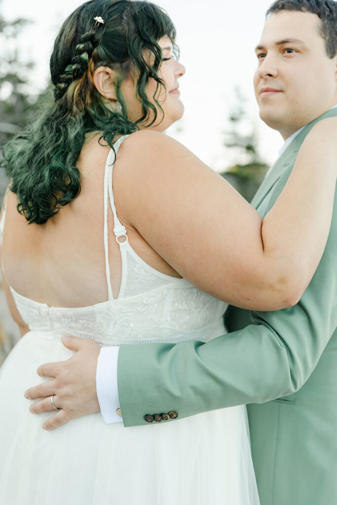 A tender moment as the groom embraces his bride, capturing the love and joy of their Acadia National Park elopement.