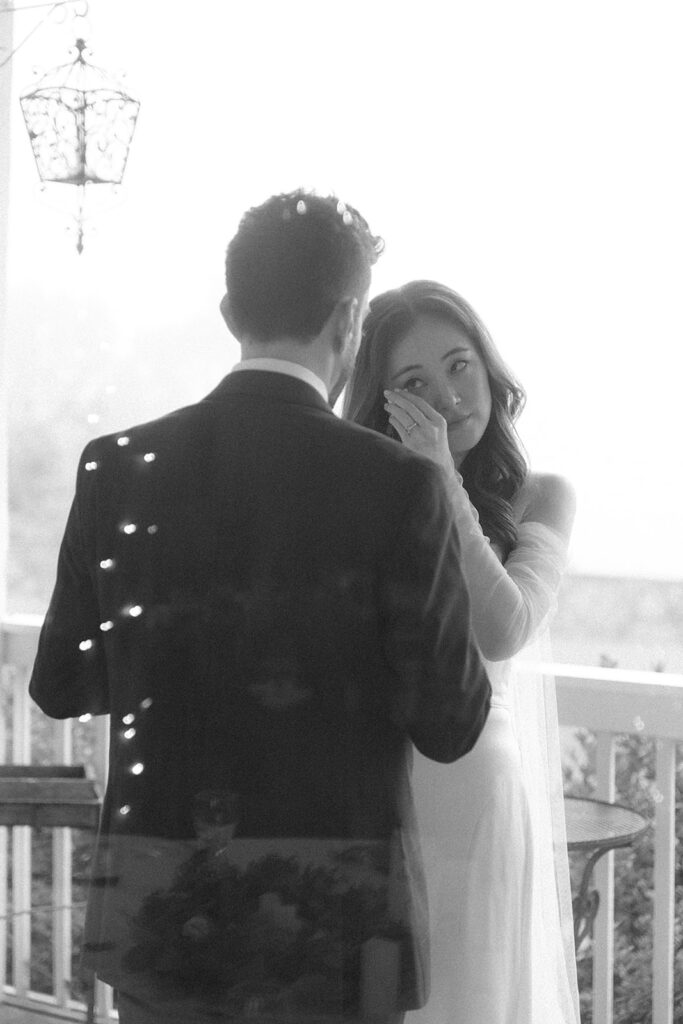 Bride wiping away tears while dancing with the groom during an emotional moment at Bluemont Vineyard.