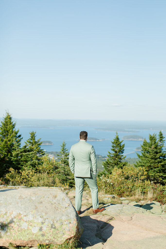 Calvin stands on Cadillac Mountain, gazing out over the expansive views of Acadia National Park and the Atlantic Ocean.