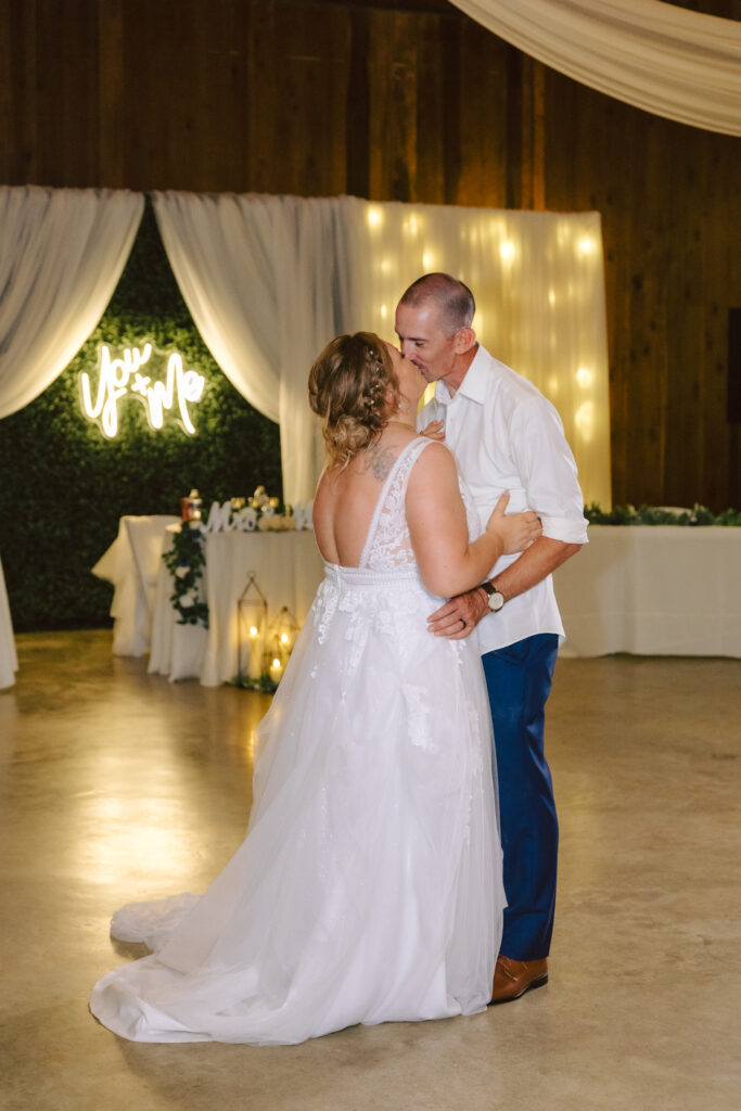 Bride and groom share a romantic first dance at Bowles Farm, surrounded by elegant decor, drapery, and glowing lights.