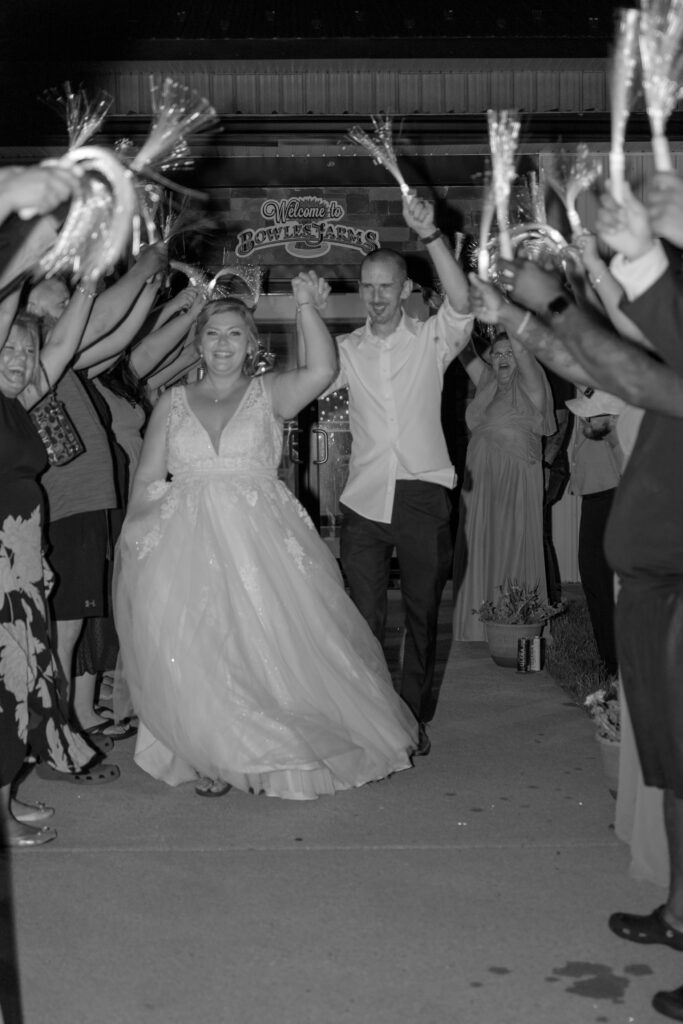 Bride and groom walk arm-in-arm through a sparkler exit at Bowles Farm, celebrating the end of their wedding night with friends and family.